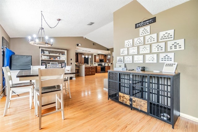 10954 96th St, Largo, FL 33773 - dining space with a chandelier, light wood-style flooring, lofted ceiling, and a textured ceiling