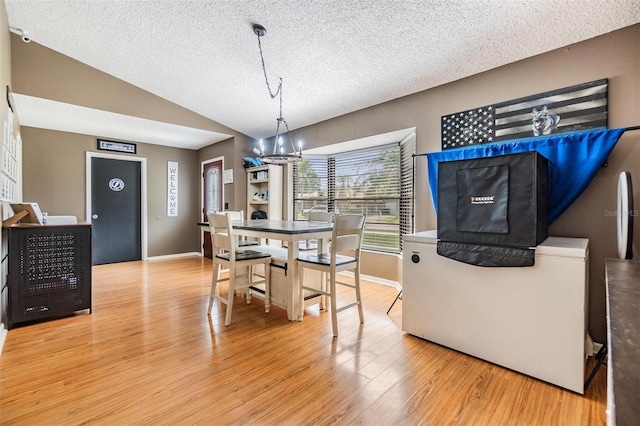 10954 96th St, Largo, FL 33773 - dining space featuring a textured ceiling, wood finished floors, lofted ceiling, and baseboards