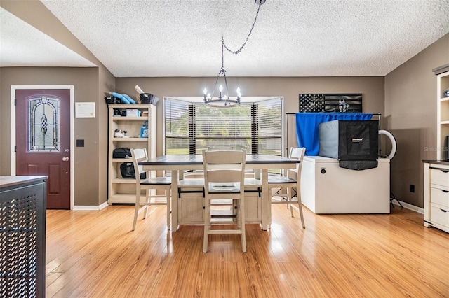 10954 96th St, Largo, FL 33773 - dining area with a chandelier, light wood-type flooring, a textured ceiling, and baseboards