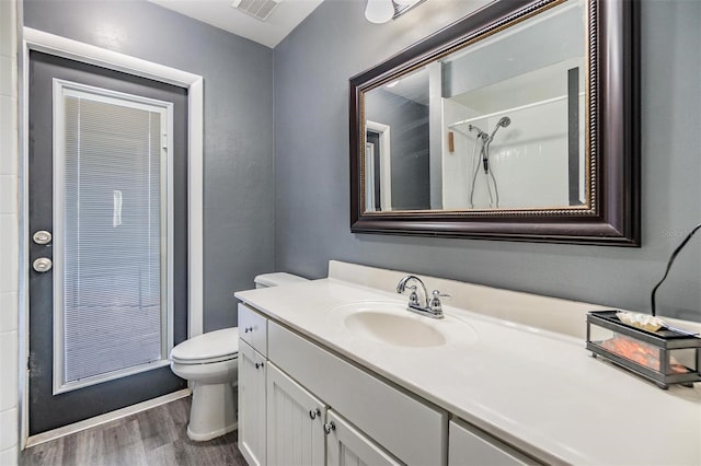 10954 96th St, Largo, FL 33773 - bathroom featuring wood finished floors, toilet, vanity, and a shower