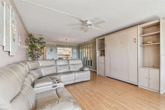 17920 Gulf Blvd Unit 208, Redington Shores, FL 33708 - living room featuring ceiling fan, a textured ceiling, and light wood-style floors