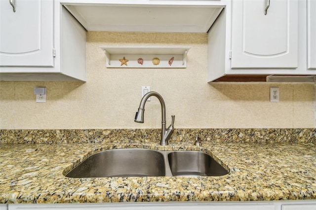 17920 Gulf Blvd Unit 208, Redington Shores, FL 33708 - kitchen view of a sink, decorative backsplash, white cabinets, and light stone countertops