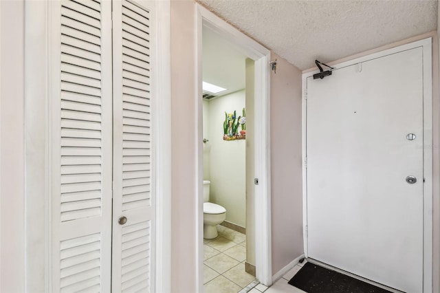 17920 Gulf Blvd Unit 208, Redington Shores, FL 33708 - bathroom featuring toilet, a closet, a textured ceiling, tile patterned floors, and baseboards