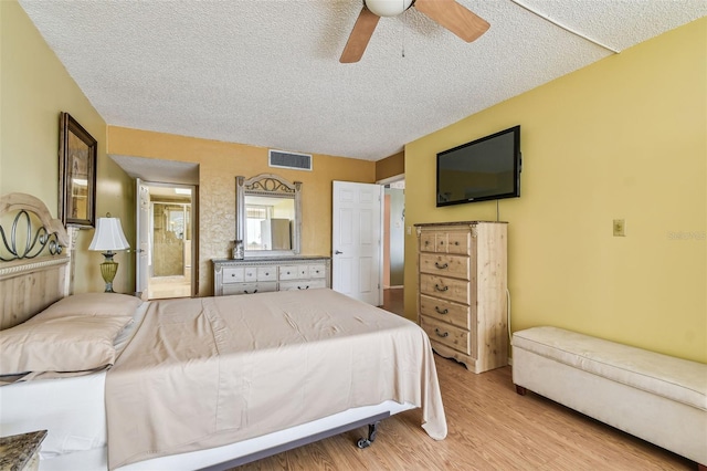 17920 Gulf Blvd Unit 208, Redington Shores, FL 33708 - bedroom featuring a textured ceiling, light wood-style flooring, ensuite bathroom, and ceiling fan