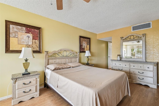 17920 Gulf Blvd Unit 208, Redington Shores, FL 33708 - bedroom with wood finished floors, a textured ceiling, and a ceiling fan
