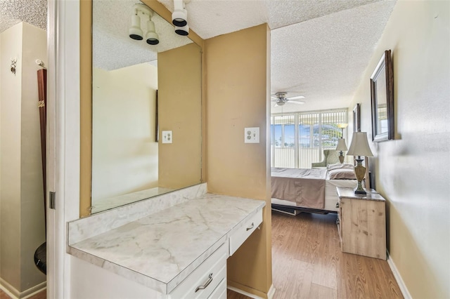 17920 Gulf Blvd Unit 208, Redington Shores, FL 33708 - bathroom featuring a textured ceiling, wood finished floors, ceiling fan, connected bathroom, and vanity