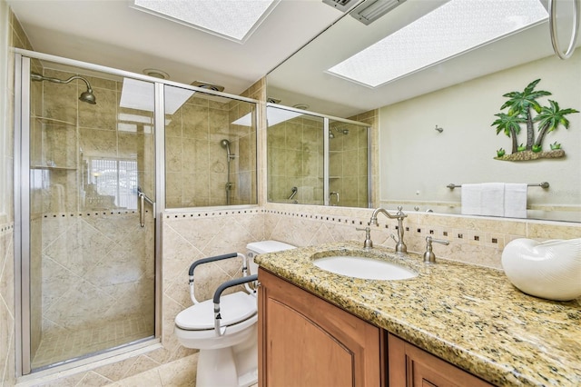 17920 Gulf Blvd Unit 208, Redington Shores, FL 33708 - bathroom with a skylight, vanity, toilet, tile walls, and a stall shower