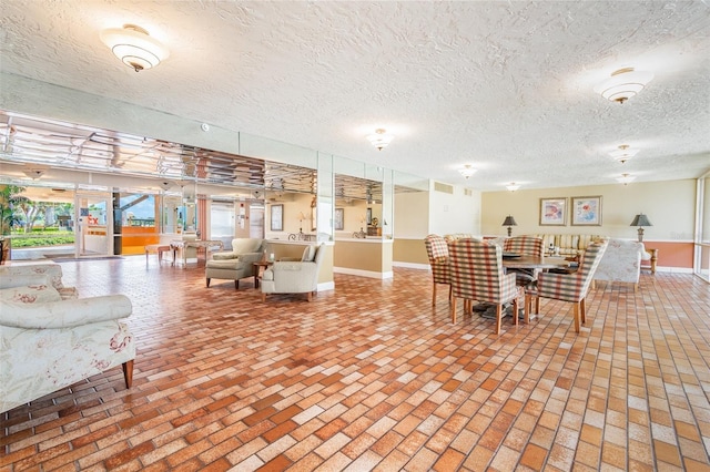 17920 Gulf Blvd Unit 208, Redington Shores, FL 33708 - dining area featuring brick floors, baseboards, and a textured ceiling