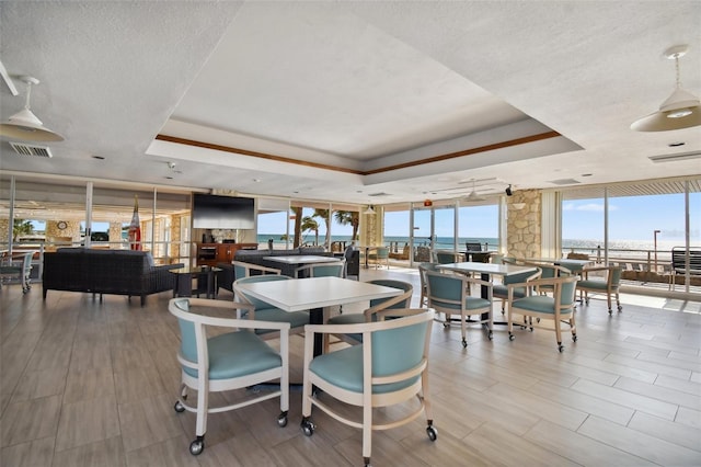 17920 Gulf Blvd Unit 208, Redington Shores, FL 33708 - dining room featuring a tray ceiling, floor to ceiling windows, a textured ceiling, and wood finished floors