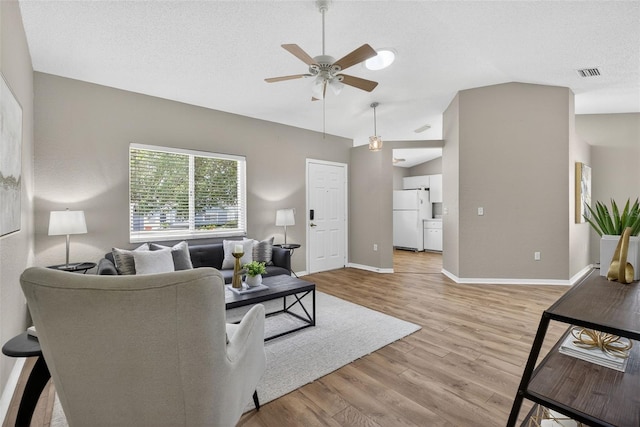 8175 Sturbridge Unit 8175, Weeki Wachee, FL 34613 - living area with lofted ceiling, a ceiling fan, light wood finished floors, and a textured ceiling