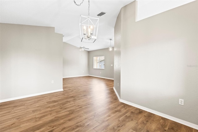 8175 Sturbridge Unit 8175, Weeki Wachee, FL 34613 - spare room with a chandelier, ceiling fan, wood finished floors, a towering ceiling, and arched walkways