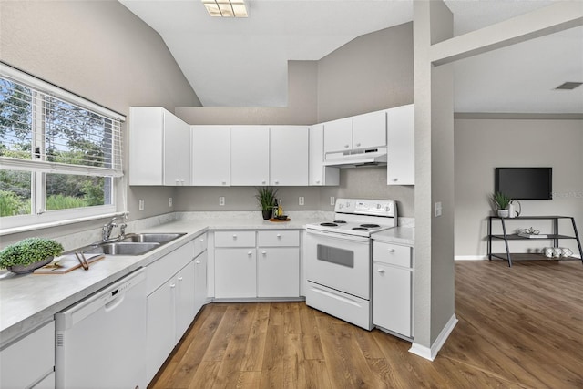 8175 Sturbridge Unit 8175, Weeki Wachee, FL 34613 - kitchen featuring white appliances, under cabinet range hood, vaulted ceiling, light countertops, and light wood-style floors