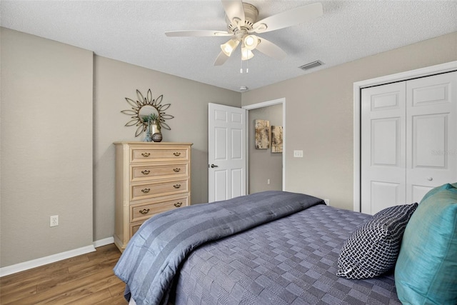 8175 Sturbridge Unit 8175, Weeki Wachee, FL 34613 - bedroom featuring wood finished floors, a closet, a textured ceiling, and ceiling fan
