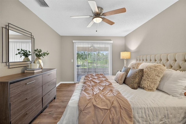 8175 Sturbridge Unit 8175, Weeki Wachee, FL 34613 - bedroom featuring wood finished floors, access to exterior, a textured ceiling, and ceiling fan