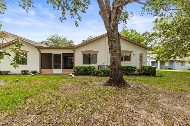 8175 Sturbridge Unit 8175, Weeki Wachee, FL 34613 - rear view of house featuring a sunroom, stucco siding, and a lawn