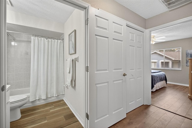 8175 Sturbridge Unit 8175, Weeki Wachee, FL 34613 - ensuite bathroom with a textured ceiling, wood-type flooring, shower / tub combo, and ceiling fan