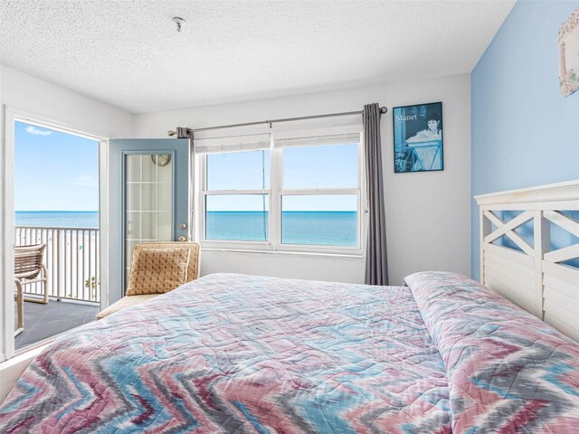 13500 Gulf Blvd Unit 706, Madeira Beach, FL 33708 - carpeted bedroom with a water view, access to outside, and a textured ceiling