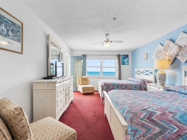 13500 Gulf Blvd Unit 706, Madeira Beach, FL 33708 - bedroom with dark colored carpet, a textured ceiling, and a ceiling fan