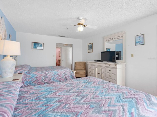 13500 Gulf Blvd Unit 706, Madeira Beach, FL 33708 - bedroom with a textured ceiling and a ceiling fan
