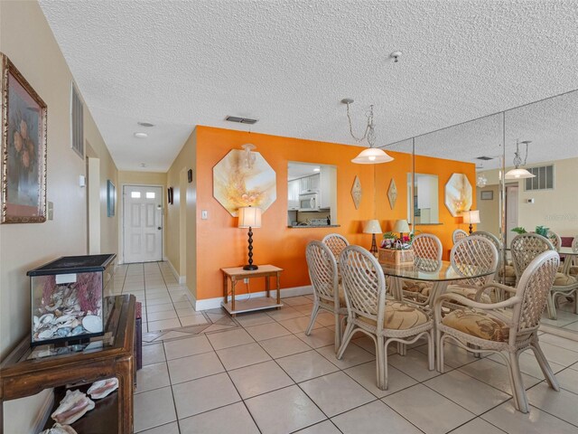 13500 Gulf Blvd Unit 706, Madeira Beach, FL 33708 - dining area with light tile patterned floors, a textured ceiling, and baseboards