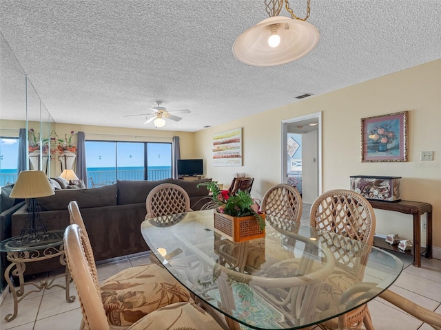 13500 Gulf Blvd Unit 706, Madeira Beach, FL 33708 - dining area with light tile patterned floors, ceiling fan, and a textured ceiling