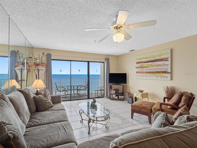 13500 Gulf Blvd Unit 706, Madeira Beach, FL 33708 - living area featuring a textured ceiling, a ceiling fan, and light tile patterned floors