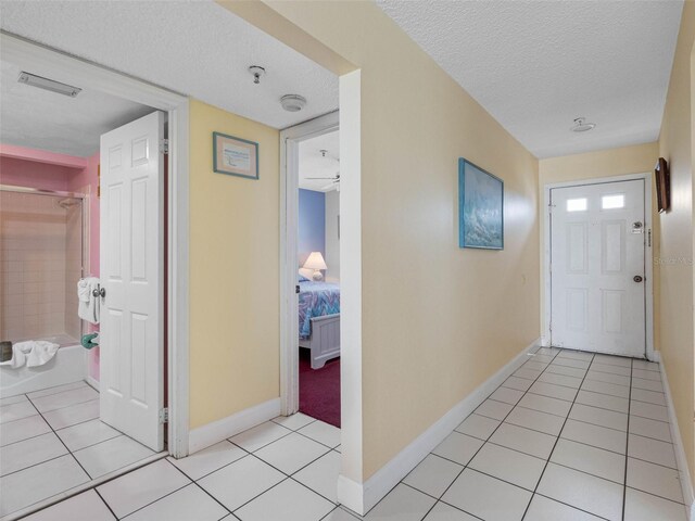 13500 Gulf Blvd Unit 706, Madeira Beach, FL 33708 - corridor with a textured ceiling, baseboards, and light tile patterned floors