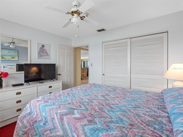 13500 Gulf Blvd Unit 706, Madeira Beach, FL 33708 - bedroom featuring ceiling fan, a closet, and a textured ceiling