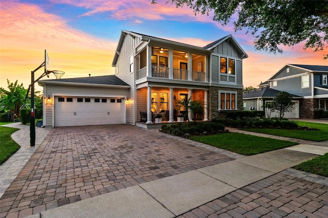 15936 Ternglade Dr, Lithia, FL 33547 - view of front of home featuring a balcony, board and batten siding, decorative driveway, an attached garage, and a porch