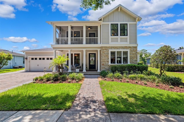 15936 Ternglade Dr, Lithia, FL 33547 - view of front facade with covered porch, a balcony, stone siding, a front lawn, and board and batten siding
