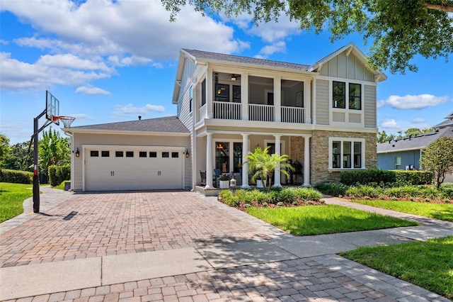 15936 Ternglade Dr, Lithia, FL 33547 - view of front of property with a porch, decorative driveway, stone siding, board and batten siding, and an attached garage