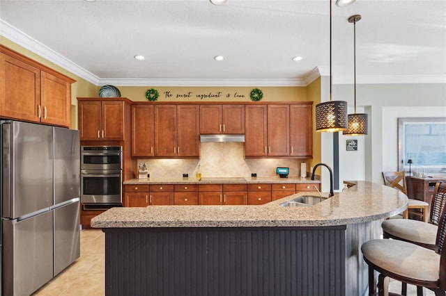 15936 Ternglade Dr, Lithia, FL 33547 - kitchen featuring stainless steel appliances, a sink, brown cabinetry, backsplash, and under cabinet range hood