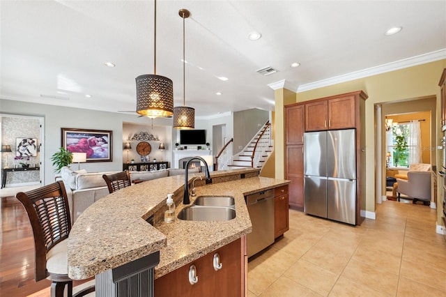 15936 Ternglade Dr, Lithia, FL 33547 - kitchen with appliances with stainless steel finishes, a sink, open floor plan, brown cabinetry, and a kitchen island with sink