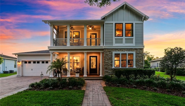 15936 Ternglade Dr, Lithia, FL 33547 - view of front facade with a balcony, covered porch, stone siding, decorative driveway, and board and batten siding