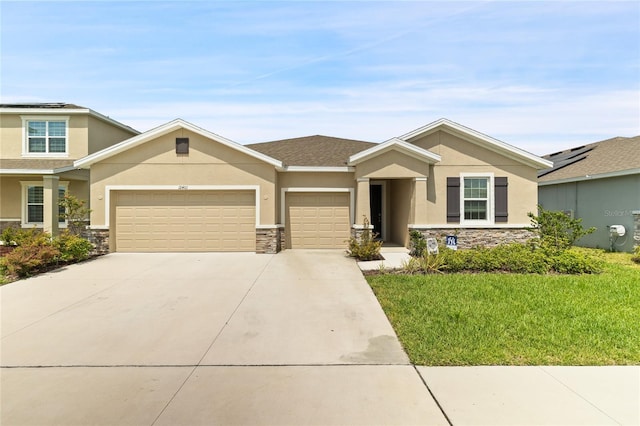 12401 Shining Willow St, Riverview, FL 33579 - view of front of home featuring stone siding, stucco siding, an attached garage, driveway, and a front yard