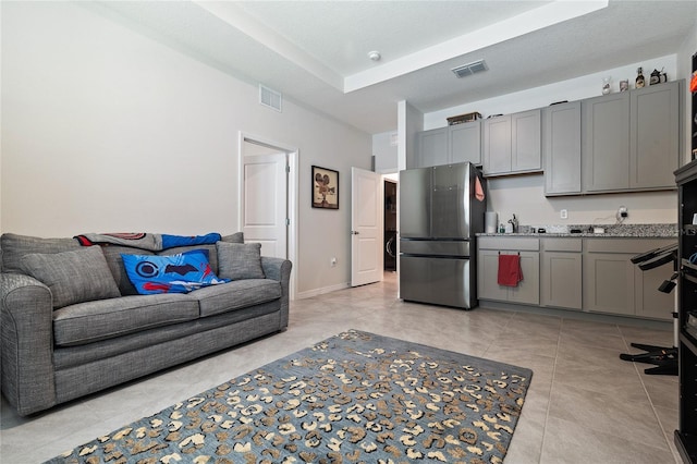 12401 Shining Willow St, Riverview, FL 33579 - kitchen with freestanding refrigerator, gray cabinetry, and light tile patterned floors
