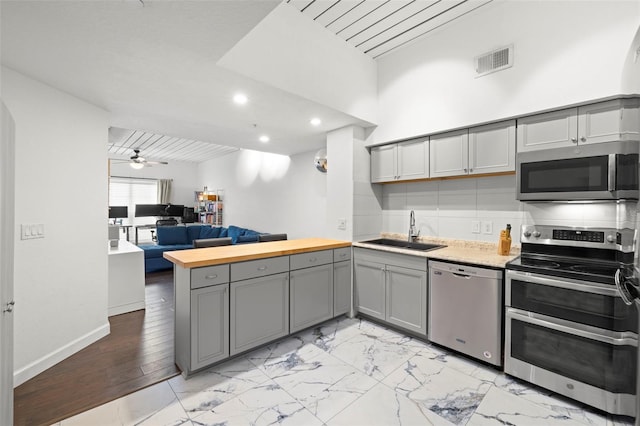 2410 W Azeele St Unit 214, Tampa, FL 33609 - kitchen featuring appliances with stainless steel finishes, gray cabinetry, open floor plan, a peninsula, and recessed lighting