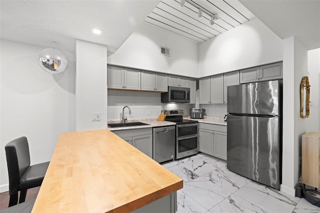 2410 W Azeele St Unit 214, Tampa, FL 33609 - kitchen featuring stainless steel appliances, gray cabinets, light marble finish flooring, a high ceiling, and a peninsula