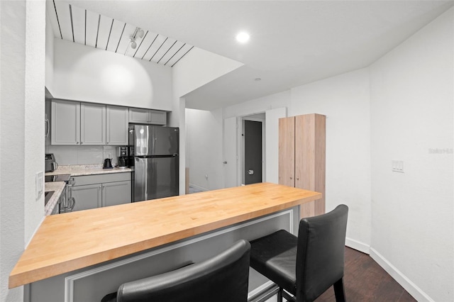 2410 W Azeele St Unit 214, Tampa, FL 33609 - kitchen featuring freestanding refrigerator, gray cabinetry, wooden counters, and a kitchen breakfast bar