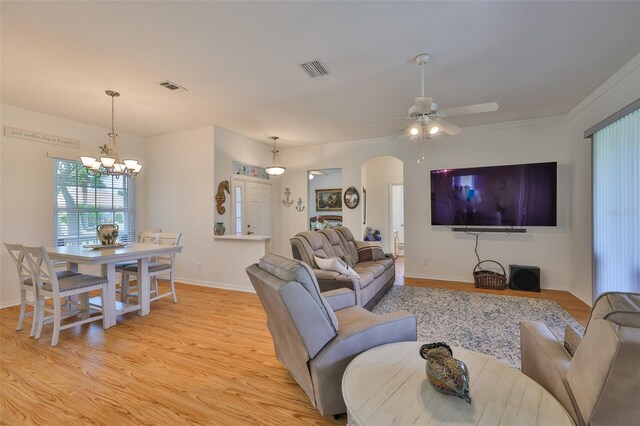 2316 Lyndhurst Dr, Sun City Center, FL 33573 - living area featuring light wood-type flooring, a chandelier, arched walkways, a ceiling fan, and baseboards