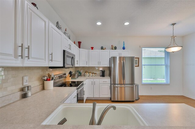 2316 Lyndhurst Dr, Sun City Center, FL 33573 - kitchen with appliances with stainless steel finishes, a sink, white cabinets, light countertops, and recessed lighting