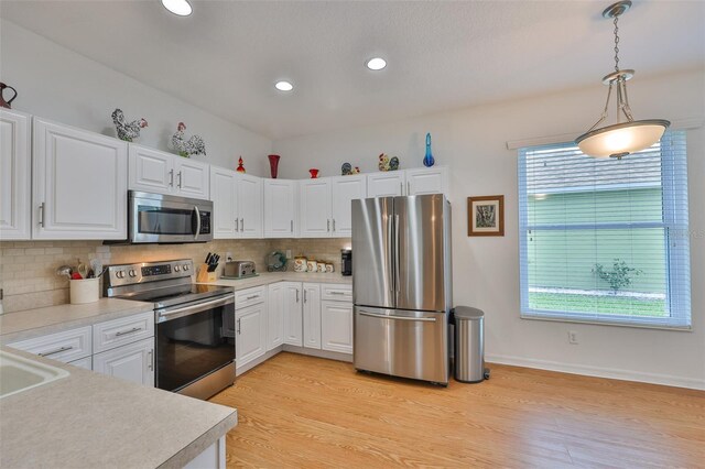 2316 Lyndhurst Dr, Sun City Center, FL 33573 - kitchen featuring stainless steel appliances, light countertops, backsplash, white cabinets, and recessed lighting
