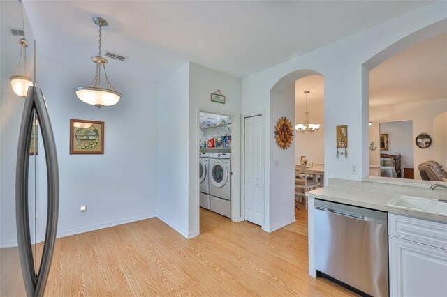 2316 Lyndhurst Dr, Sun City Center, FL 33573 - kitchen featuring stainless steel appliances, independent washer and dryer, a sink, a chandelier, and light wood-style floors