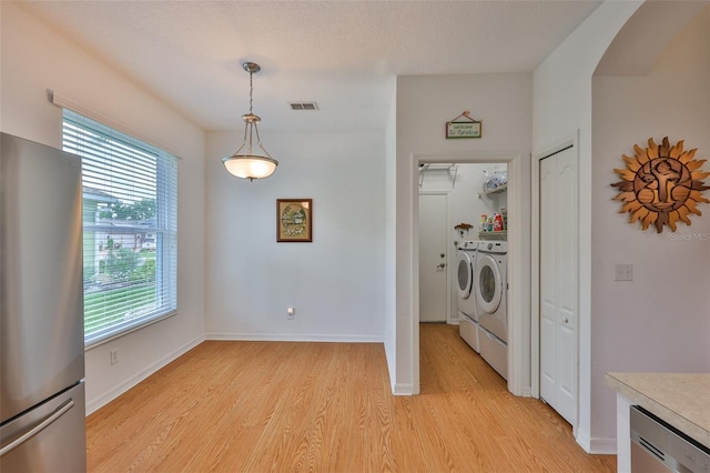 2316 Lyndhurst Dr, Sun City Center, FL 33573 - laundry area featuring separate washer and dryer, light wood-type flooring, and baseboards
