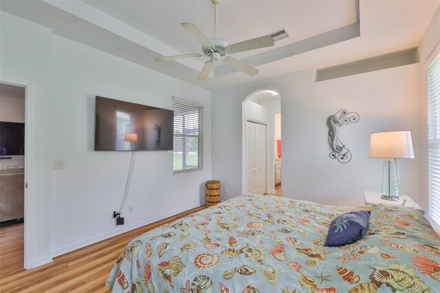 2316 Lyndhurst Dr, Sun City Center, FL 33573 - bedroom with wood finished floors, arched walkways, a closet, ceiling fan, and baseboards