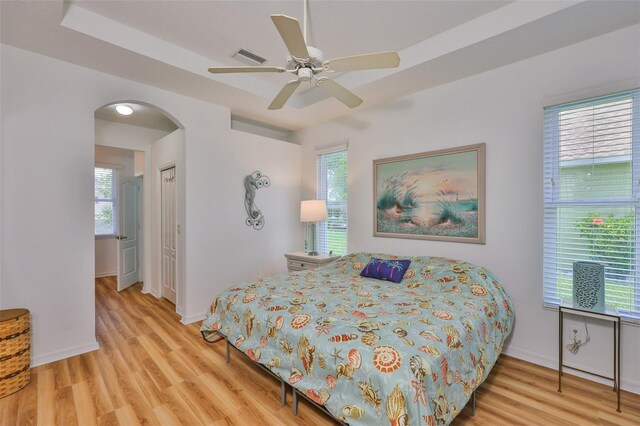 2316 Lyndhurst Dr, Sun City Center, FL 33573 - bedroom featuring wood finished floors, arched walkways, baseboards, and multiple windows