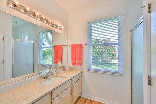 2316 Lyndhurst Dr, Sun City Center, FL 33573 - bathroom with a shower with shower door, vanity, wood finished floors, and baseboards