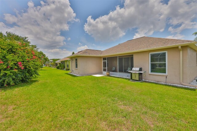 2316 Lyndhurst Dr, Sun City Center, FL 33573 - rear view of house with stucco siding and a lawn