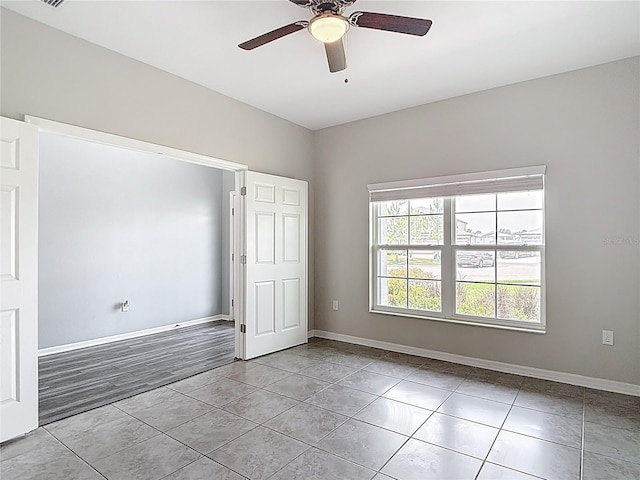 7628 Surf Reed Way, Wesley Chapel, FL 33545 - unfurnished room with a ceiling fan, light tile patterned floors, and baseboards