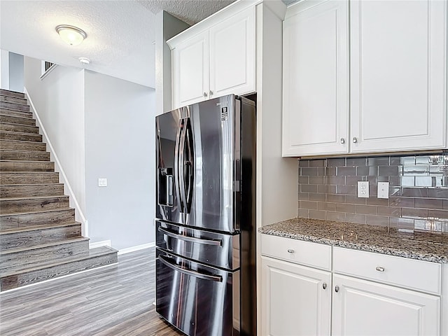 7628 Surf Reed Way, Wesley Chapel, FL 33545 - kitchen featuring stainless steel fridge, baseboards, dark stone countertops, tasteful backsplash, and a textured ceiling